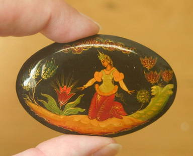 vintage estate jewelry: Russian lacquer pin brooch: vintage lacquered oval pin brooch, with hand painted design of a beautiful woman kneeling and looking at wild flowers, probably a storybook or fairy tale depiction