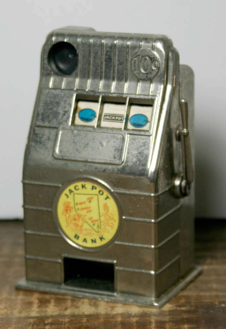 vintage slot machine coin bank: vintage metal coin bank shaped like a pull handle slot machine and with Jackpot Bank sticker, made by Reno Plastic Mfg Company from Nevada