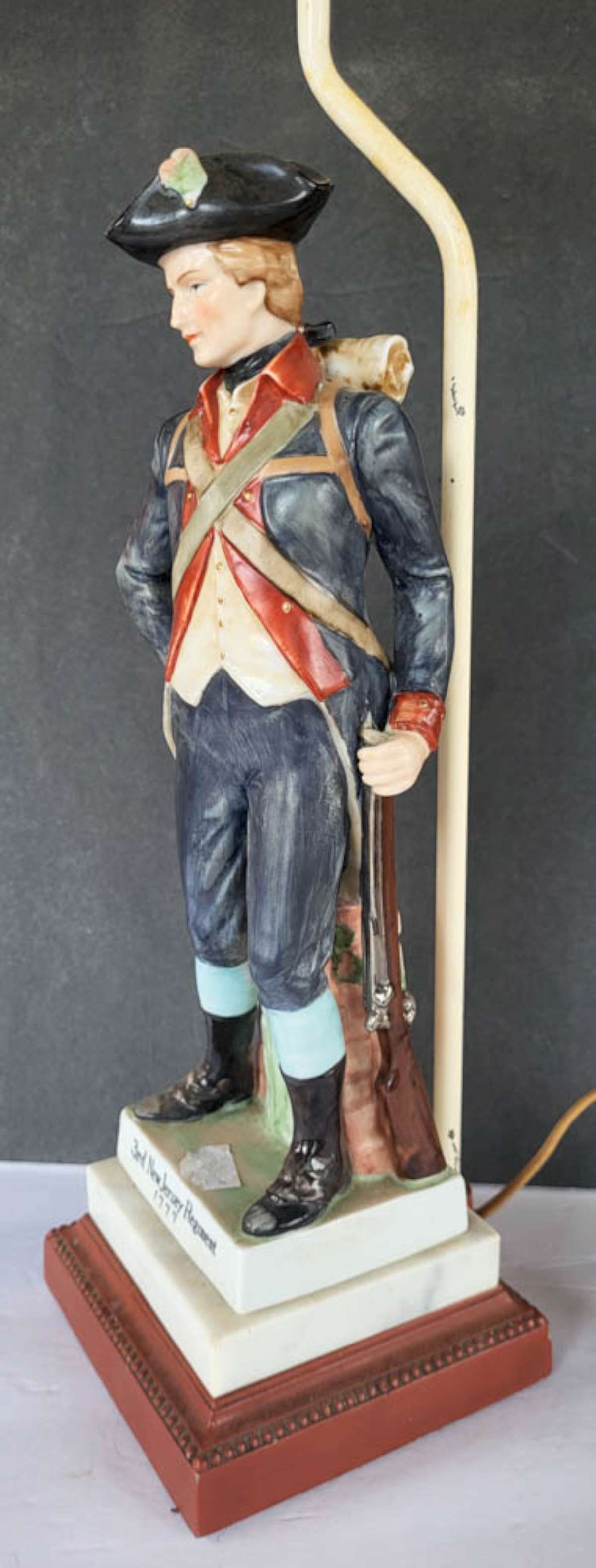 vintage military table lamp: vintage porcelain or bisque figural lamp, titled 3rd New Jersey Regiment 1777 and depicting a soldier in his uniform and tricorn hat, holding his rifle, on a wooden base