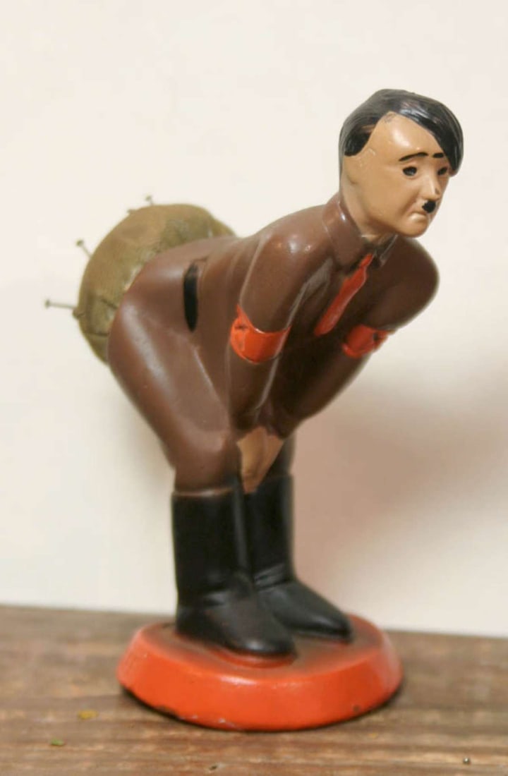 vintage propaganda Hitler pin cushion toy: vintage Hitler caricature moulded toy with his behind as a pin cushion for sewing and with a sad look on his face, called a Hotzi-Notzi and produced Patent Pending 1941 during WWII or World War 