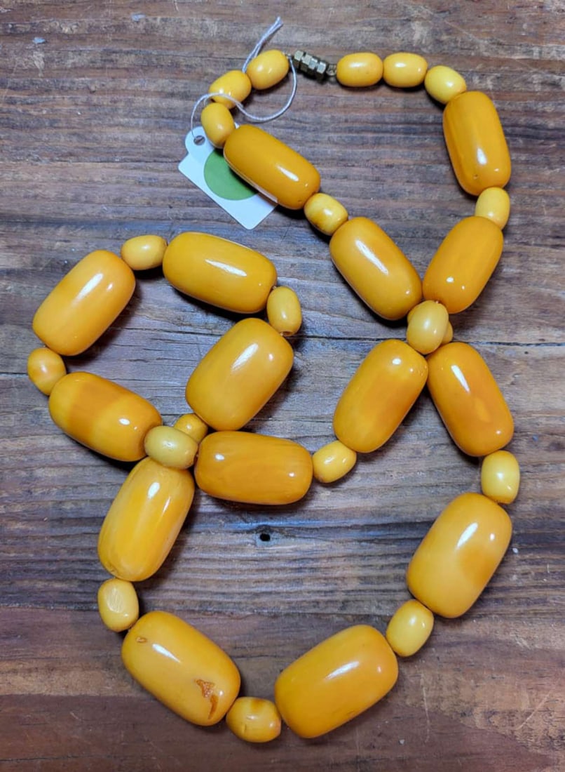 vintage estate jewelry: Bakelite necklace: vintage or antique Art Deco period long fat or chunky egg yolk yellow colored Bakelite oval beaded necklace with twist closure