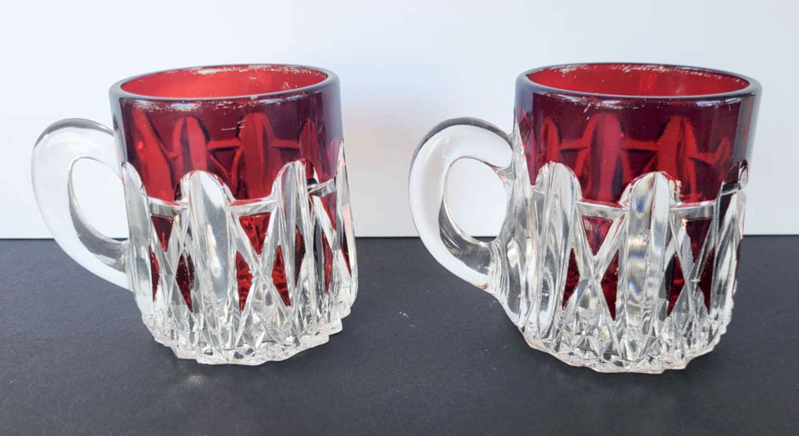 pair antique Ruby glassware mugs: matching pair of antique handled drinking glasses or cups with cut clear bottom and Ruby red top parts