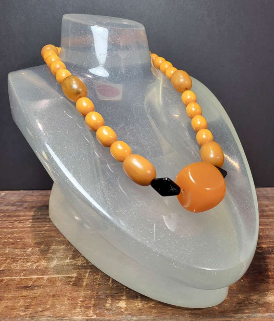 vintage estate jewelry: Bakelite necklace: vintage or antique Art Deco period long fat or chunky Bakelite oval beaded necklace with translucent (apple juice) and egg yolk yellow colors and black diamond shaped spacers to highlight the die shap