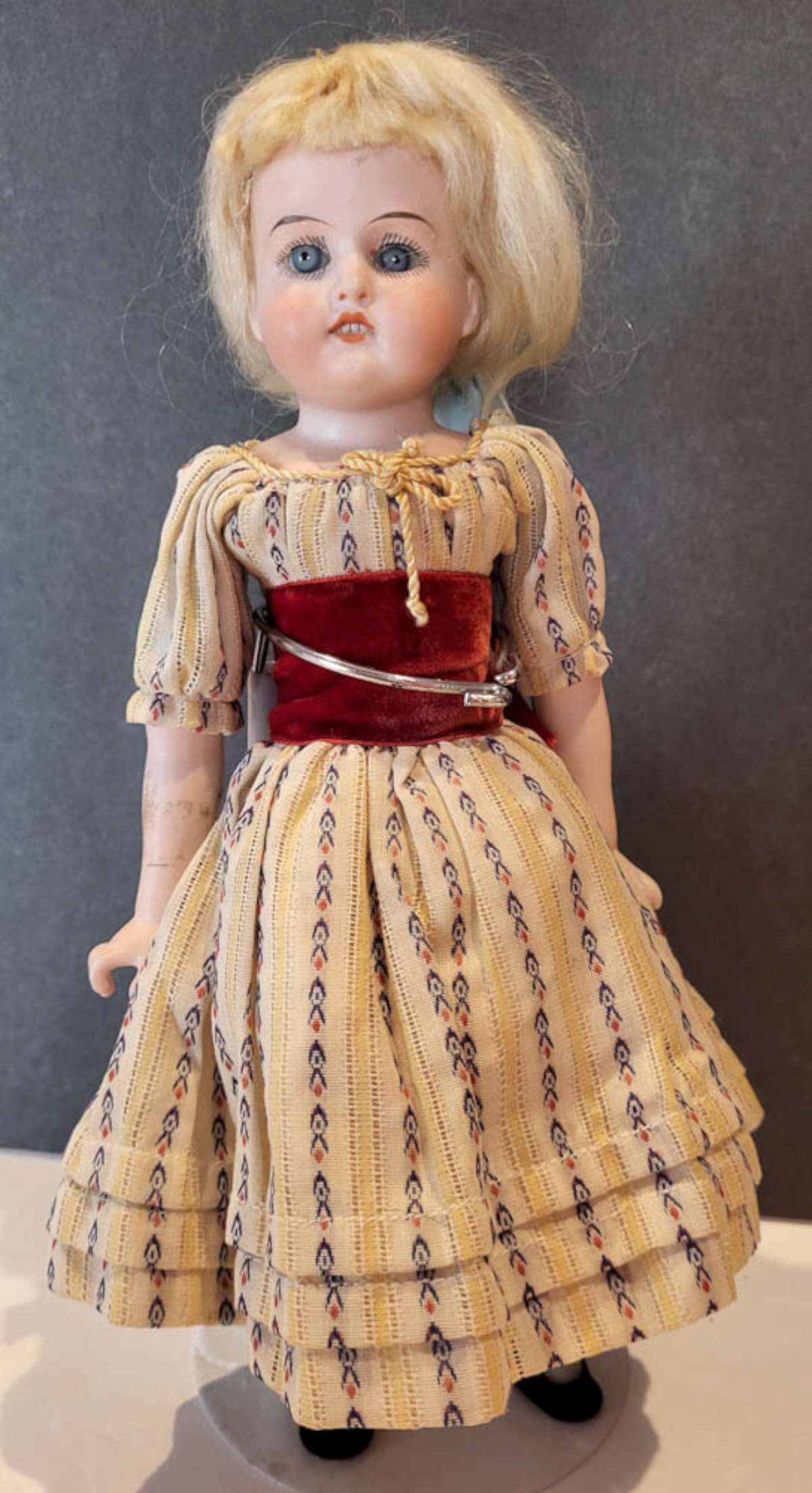 antique porcelain head girl doll: small bisque or porcelain head doll with illegible marks (possibly Armand Marseille) and a number and with open mouth and teeth showing, blue eyes and hand painted eyelashes, blonde wig an