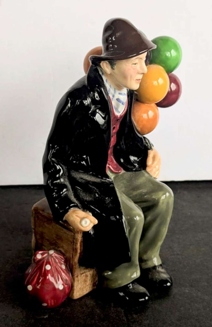 vintage Royal Doulton male figurine: marked as shown underneath Royal Doulton Made in England The Balloon Man H.N. 1954, depicting a man sitting on a crate holding several balloons