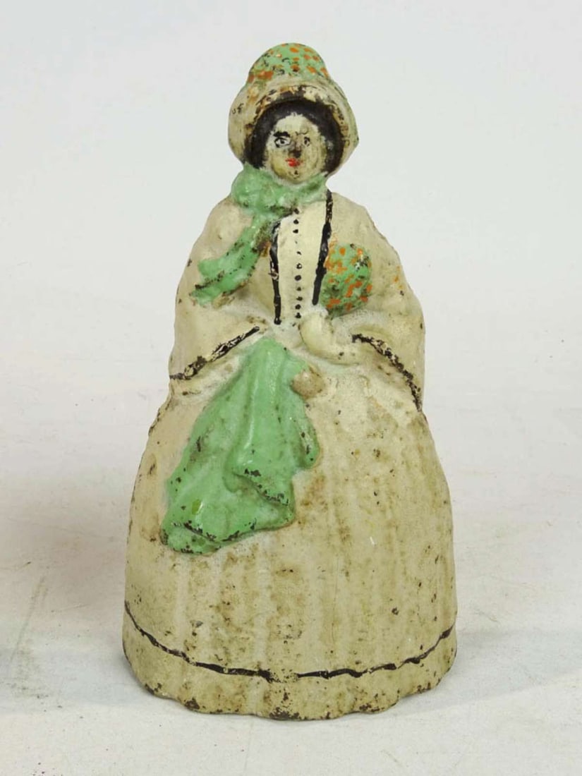 antique Hubley cast iron doorstop: antique cast iron dog doorstop, illegibly marked on the back as shown, hollow back, painted front and shaped like a Colonial lady in a white dress and bonnet with green scarf and fab
