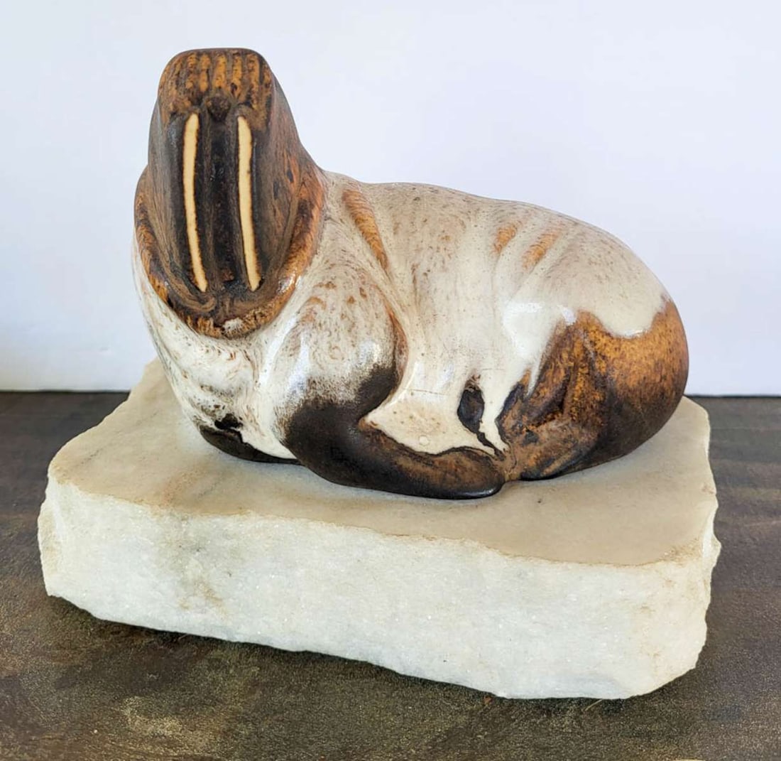 vintage pottery animal sculpture: vintage pottery Walrus or Sealion statue with white and brown glaze and set on a piece or white marble, signed by the artist Dega as shown underneath