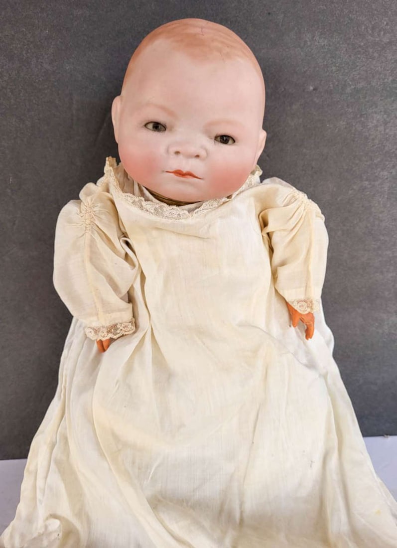 antique Grace Putnam Bye-Lo baby doll: marked 1923 bisque or porcelain head baby doll with what appears to be original clothing and with sleepy eyes and a cloth body with composite hands, comes in the vintage wooden rocking crib as s
