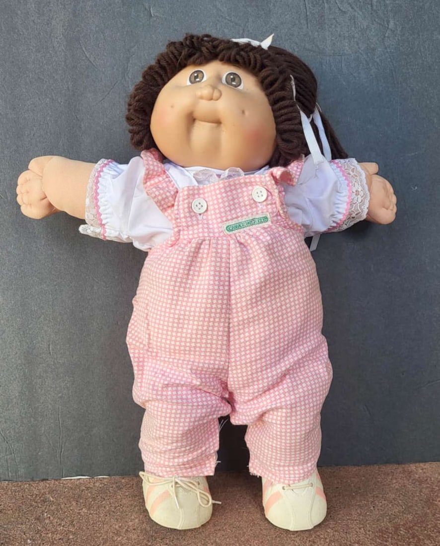 vintage Cabbage Patch girl doll: adorable original early 1980's Cabbage Patch doll with dark brown hair and light brown eyes and pink and white checkered original outfit and shoes, marked on the neck as shown