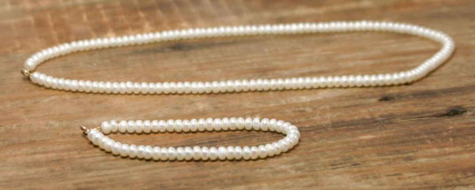 vintage estate jewelry: pearl necklace suite: matching set of a bracelet and necklace, each with 10k gold clasp closure (not sure if the symbol next to the karat is a maker's mark or GFE mark), with small baroque donut shaped fre