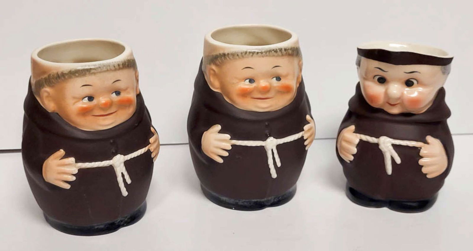 set antique Goebel monk mugs and pitcher: vintage or antique set or lot of three porcelain pieces, two handled mugs and 1 creamer or milk pitcher and depicting Friar Tuck monks in habit and marked underneath as shown bee in V West Germa