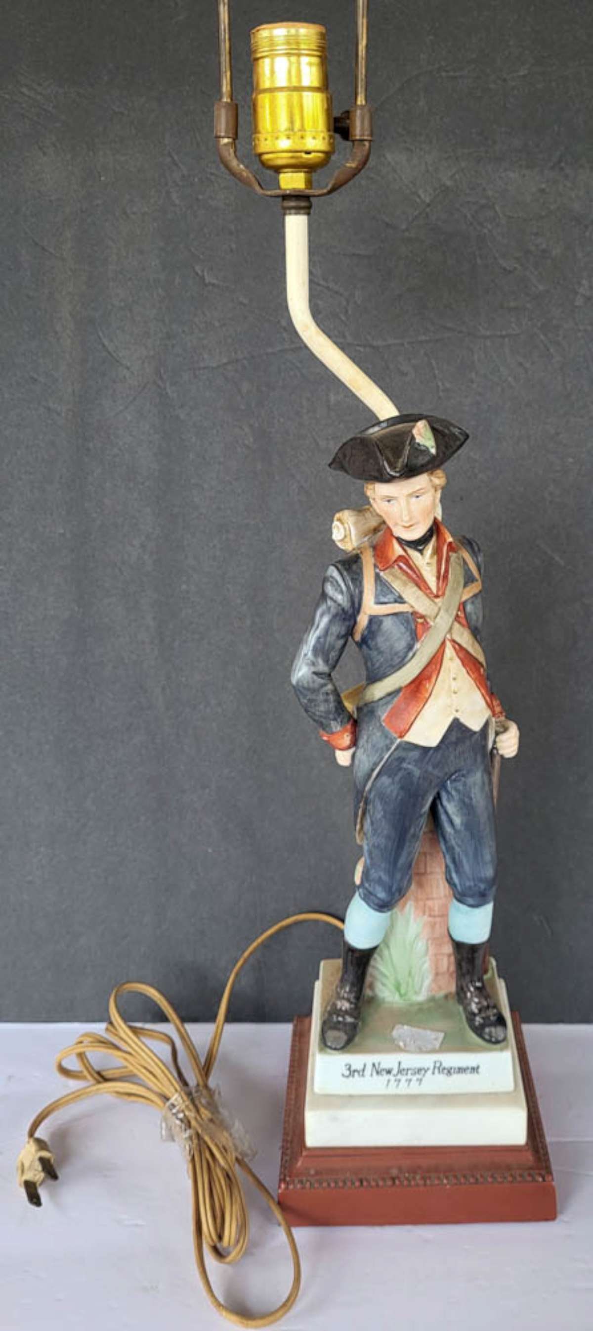 vintage military table lamp: vintage porcelain or bisque figural lamp, titled 3rd New Jersey Regiment 1777 and depicting a soldier in his uniform and tricorn hat, holding his rifle, on a wooden base