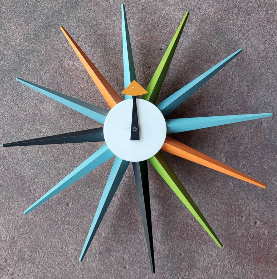 vintage George Nelson wall clock: vintage 2001 Vitra Design Museum wall clock, originally designed by George Nelson, sunburst design in various colors over metal base, battery operated