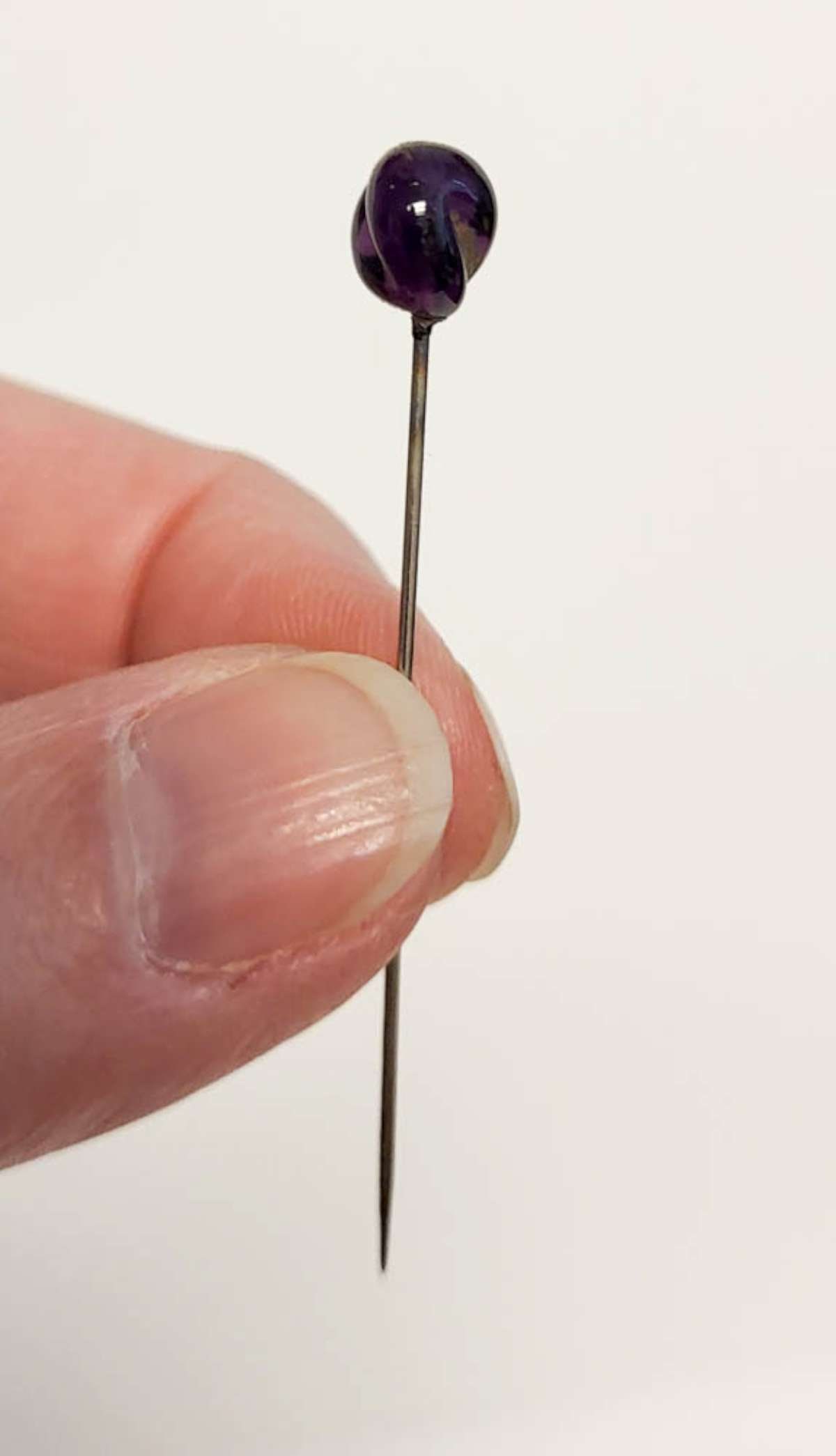 vintage hat pin glass: vintage or antique hat or lapel pin with metal post and twisted Amethyst purple glass or cut stone top