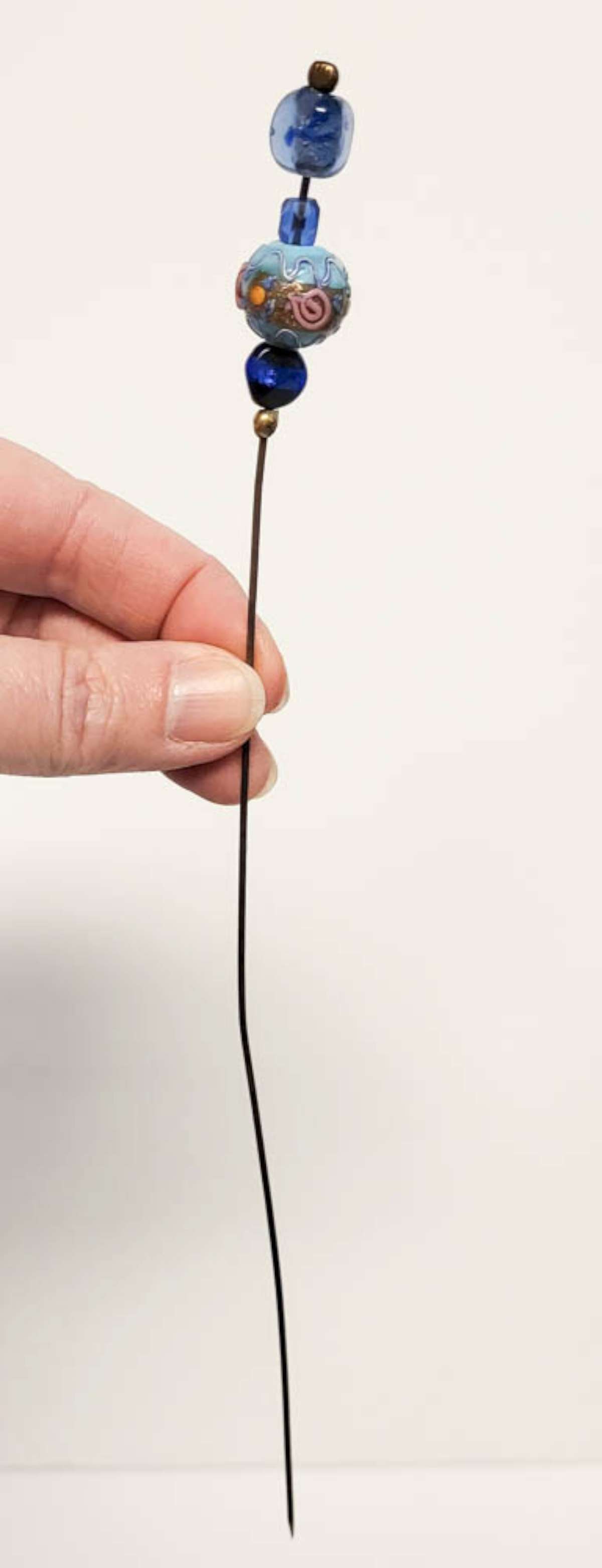 vintage hat pin Lampwork beads: vintage or antique long hat pin with metal post and beads and 4 blue glass beads one of which is a Lampwork (Venetian?) bead