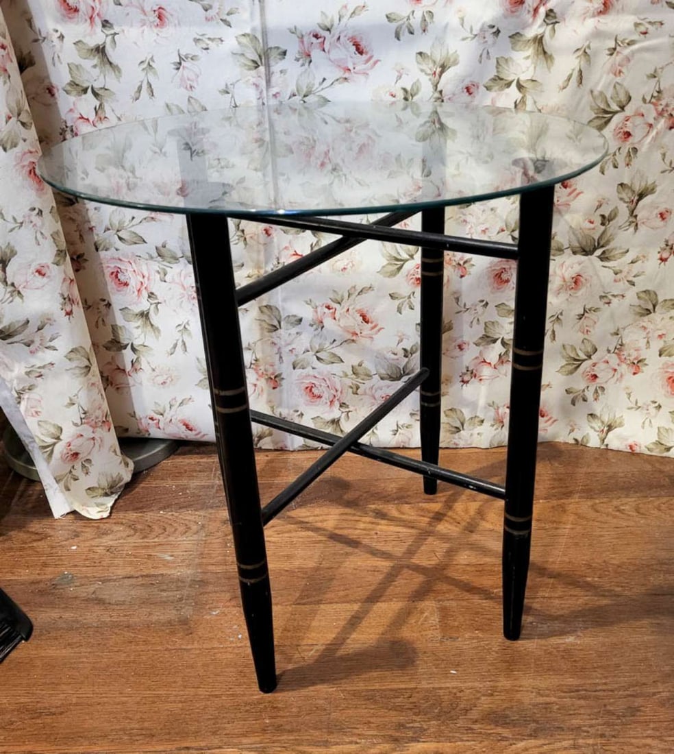 small vintage folding table with glass top: vintage ca. 1970's low side or occasional table in the Hollywood Regency style, base looks like black painted bamboo with gold bands and the x-base folds flat, a clear, round gl