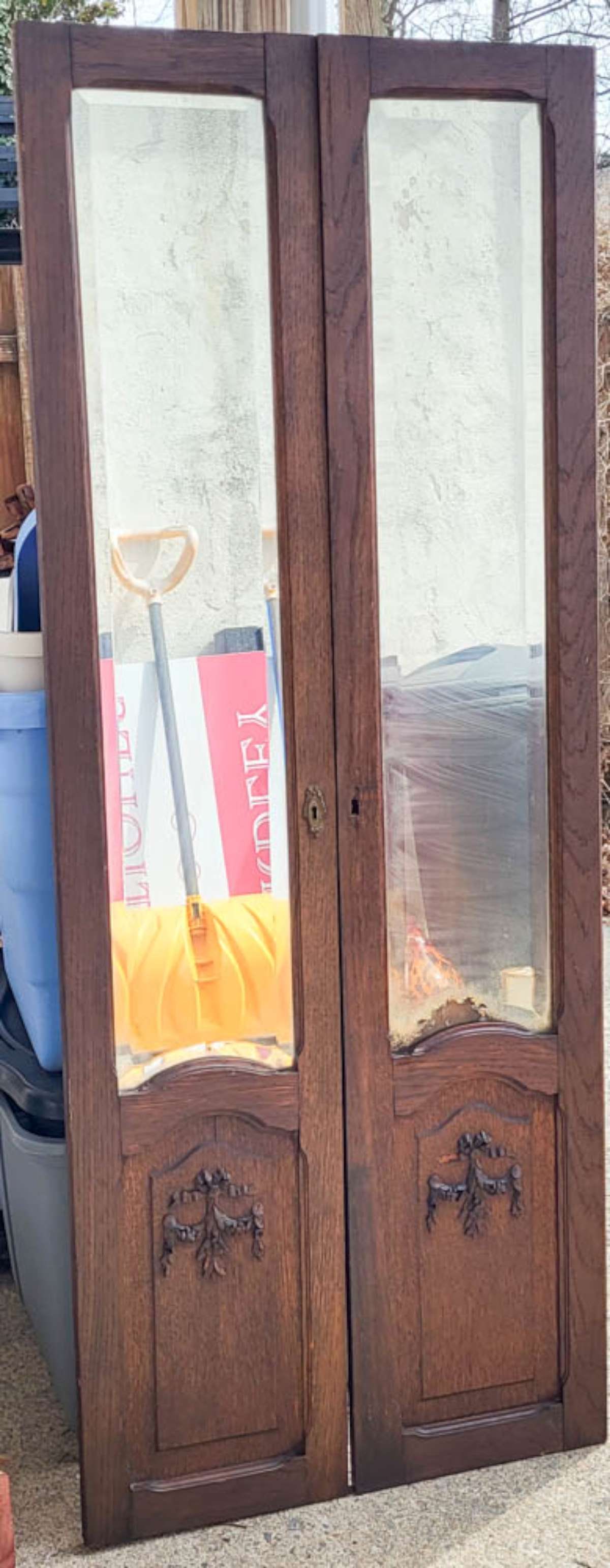 antique PAIR of carved mirrored doors: PAIR of antique oak cabinet or cupboard doors with beveled original mirrors and applied carved floral or flower ribbon wreath design