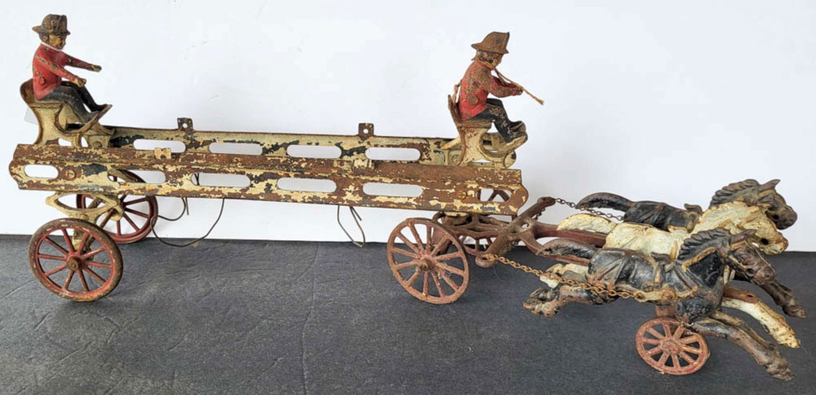 RARE antique Wilkins firetruck and horses toy: large early 1900's horse drawn cast iron hook and ladder firetruck or fireman's pumper wagon, with original horses and wheels and riders, remnants or the original paintSimilar se