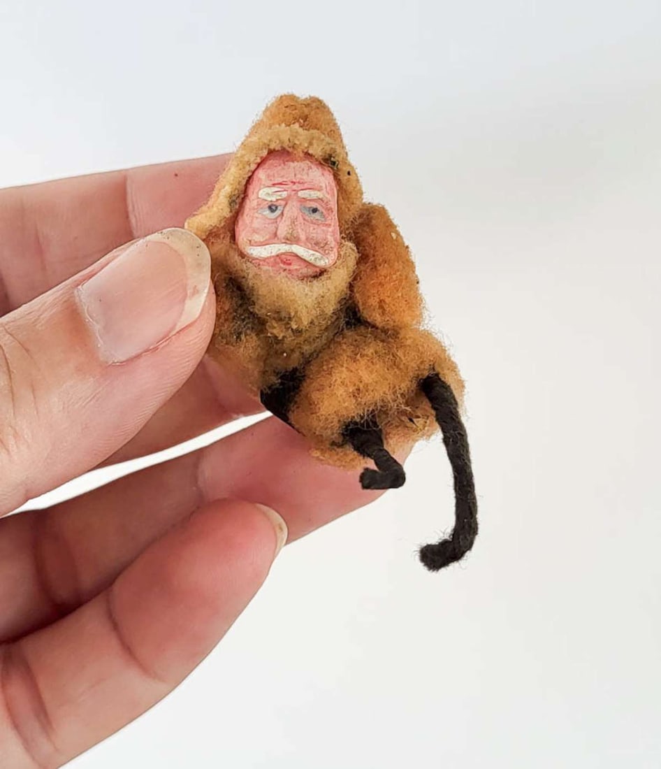 antique Belsnickle Santa: antique celluloid and felted wool Christmas Santa Claus with beard and orange-brown clothing, looks like he was part of a large scene, since his legs aren't finished