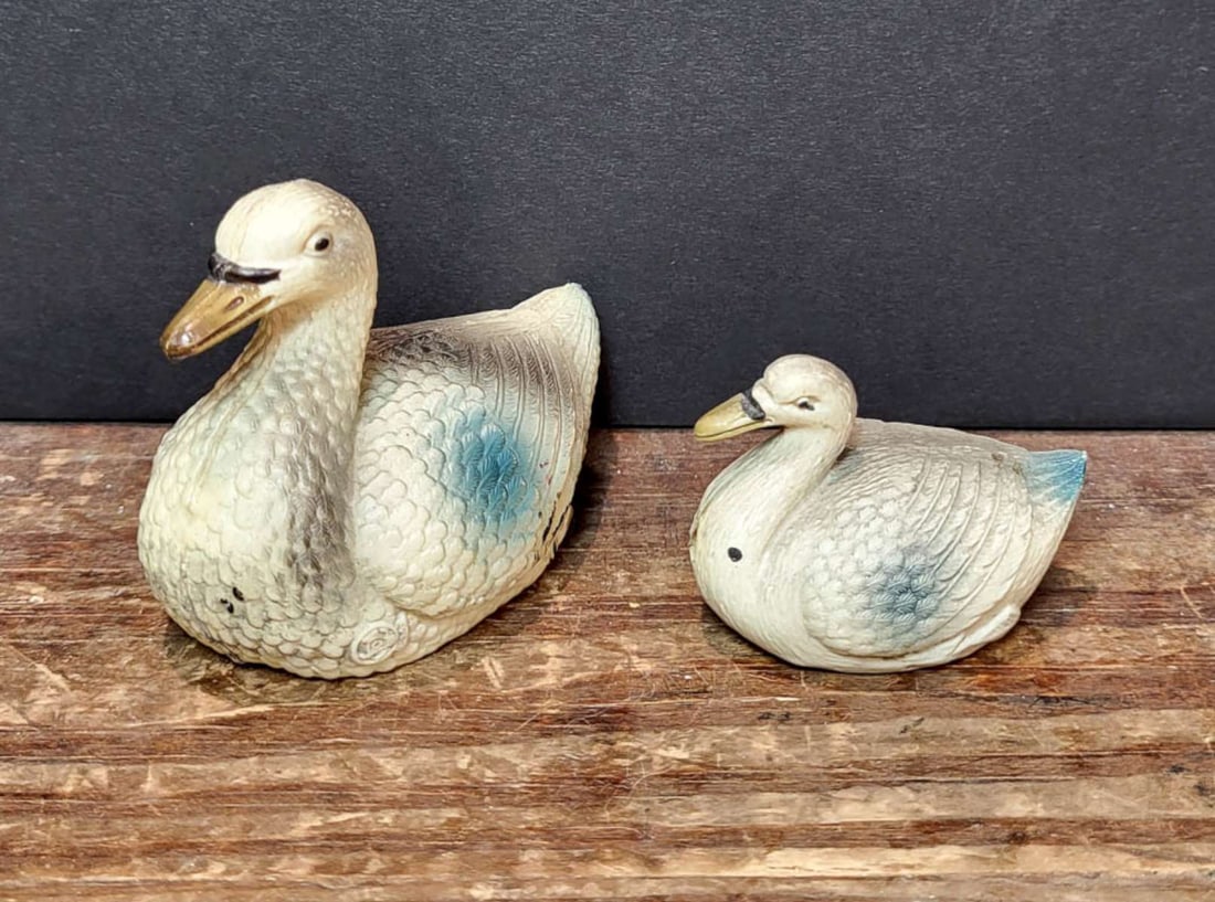 PAIR antique celluloid bird toys: set or lot of two graduating sized celluloid vintage or antique swan shaped toys, white with black, yellow and blue accent colors, smaller is marked Made in USA as shown