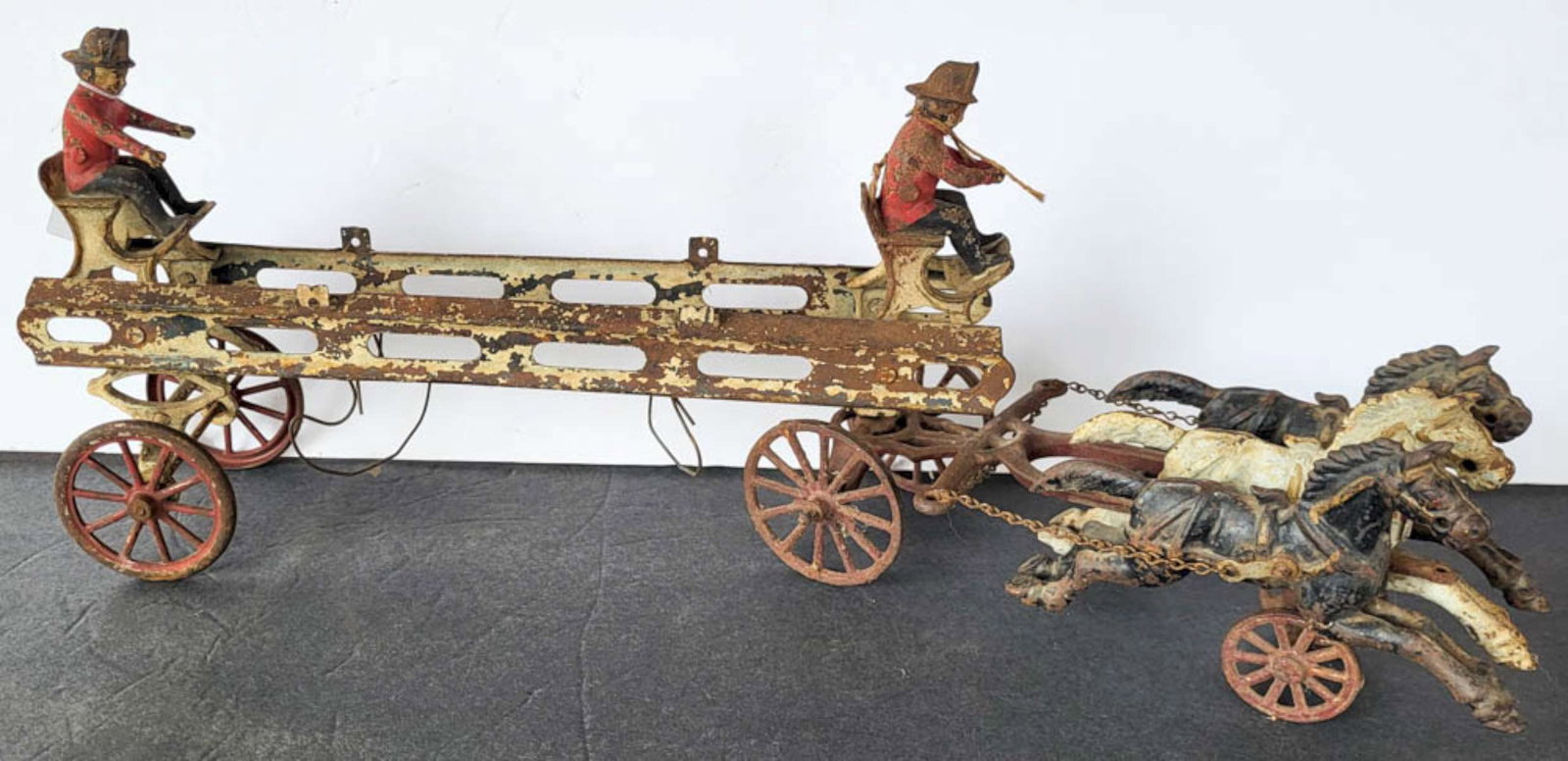 RARE antique Wilkins firetruck and horses toy: large early 1900's horse drawn cast iron hook and ladder firetruck or fireman's pumper wagon, with original horses and wheels and riders, remnants or the original paintSimilar se