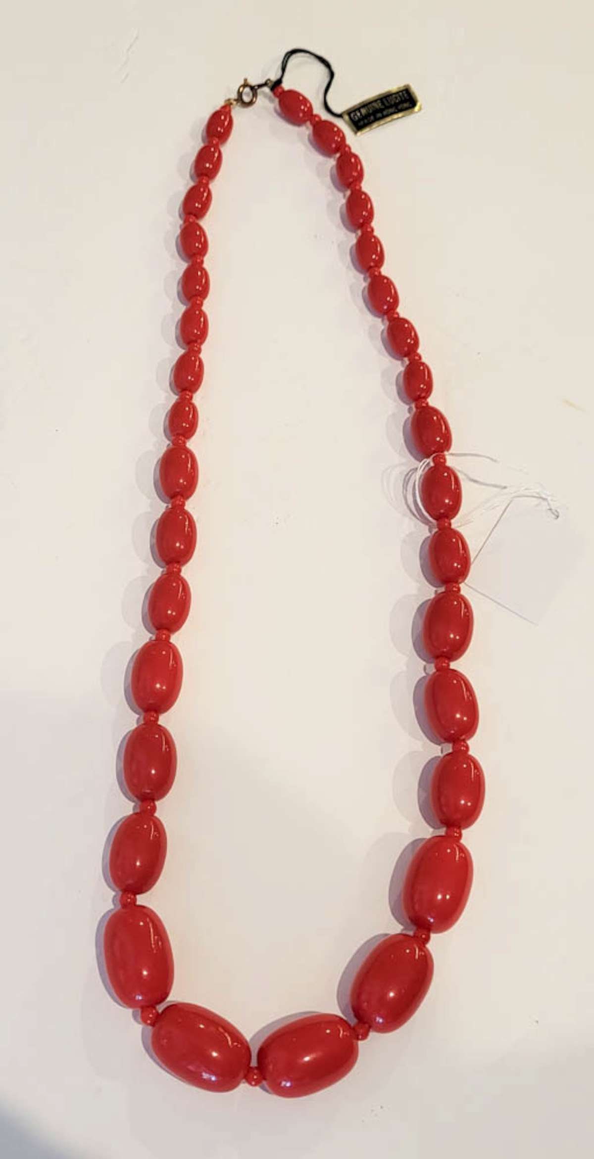 vintage estate jewelry: Lucite necklace: vintage Lucite necklace (label marked Made in Hong Kong) with oval red graduating size beads and gold toned closure