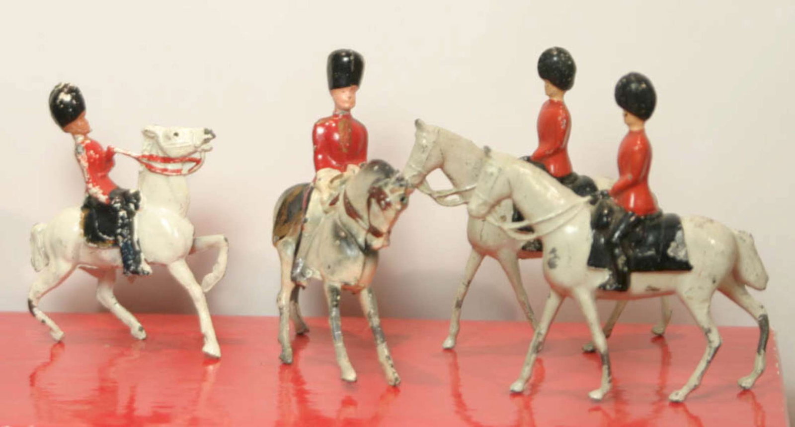 antique British soldiers on horseback toys: antique set of 4 lead or zinc toy soldiers, all on white horses and marked underneath Crescent Toys as shown