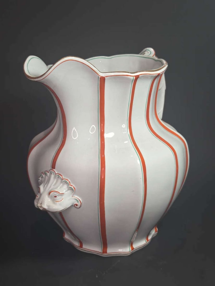 large antique handled jug with face: ca. mid-1800's unmarked (possibly Copeland) large handled pitcher with orange and green stripped design and abstract lion or other animal head applied, scalloped shaped handle