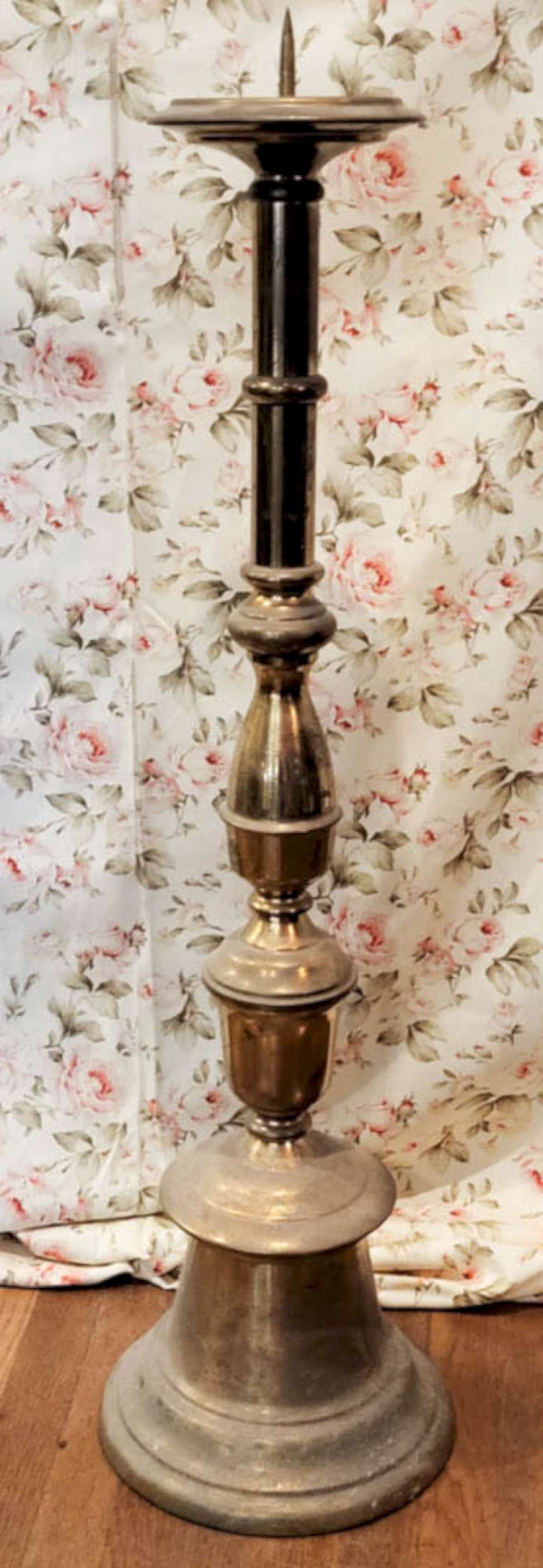 antique tall floor model candlestand: vintage or antique heavy and tall candle holder or pricket stick with a segmented design and large spike at the top, possibly from a church or funeral home (?)