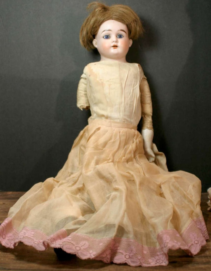 antique Heubach porcelain head girl doll: bisque head girl doll with bisque arms (1 detached, but present, see picture), leather body and linen dress, detached hair wig, stationary blue glass eyes and open mouth 