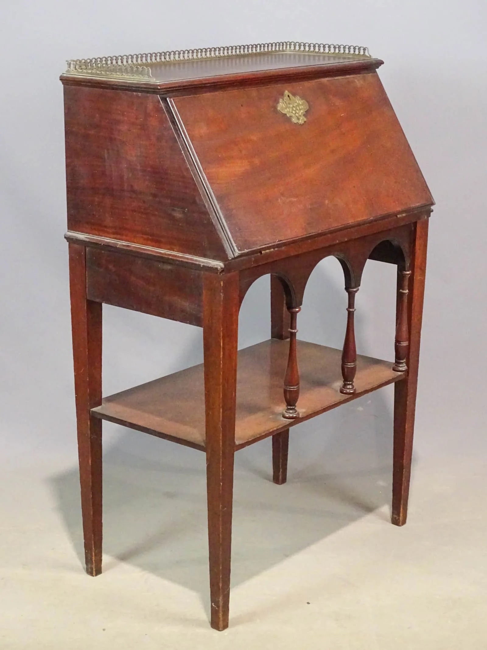 antique drop front desk on stand: antique early 1900's wooden ladies' or secretary desk on stand with drop down lid revealing cubbies, top has a brass decorative rim and the lid has a beautiful brass escutcheon plate f