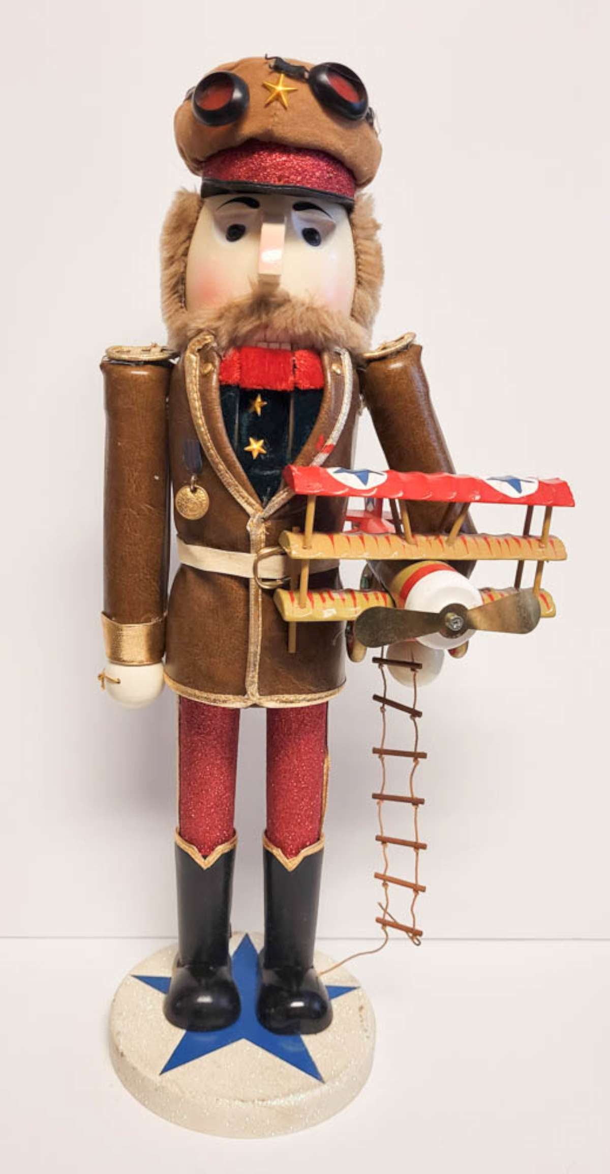 tall vintage wooden Nutcracker doll: tall wooden pilot themed Nutcracker holding an airplane