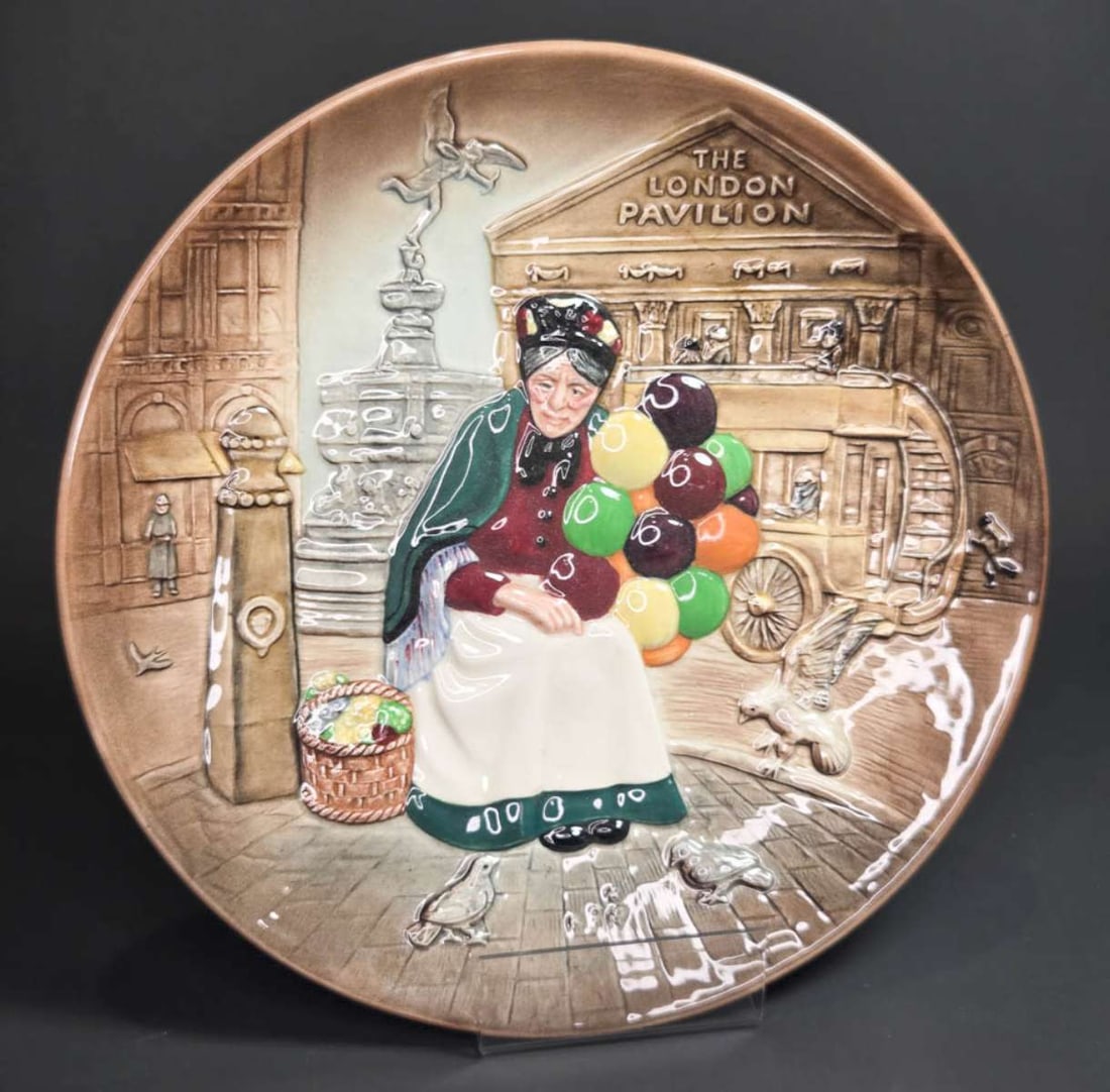 vintage Royal Doulton figural plate: vintage figural platter or large plate with 3-D design depicting an elderly lady or woman sitting in a street scene with pigeons selling colorful balloons, marked as shown underneath Royal Doult