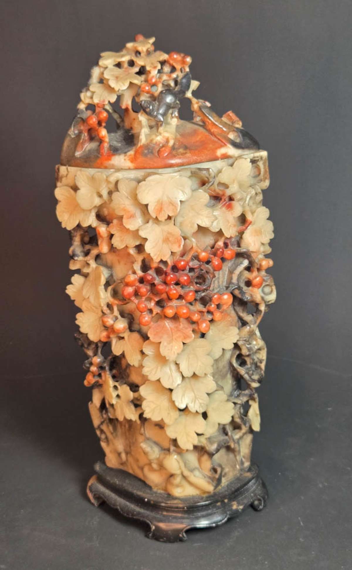 antique carved Jade lidded vessel on wooden base: vintage or antique openwork or pierced style carved Jade or Chinese soapstone vase with lid and set on a carved wooden stand, vase with berries and leaves and finished all the way around, 