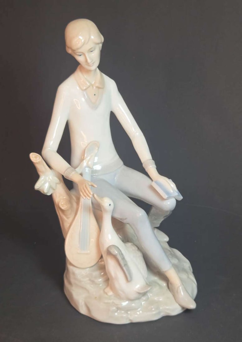 vintage figural porcelain statue: vintage porcelain blue, white and beige colored statue, depicting a man with a Lute or other musical string instrument and a book on his knee, unmarked but looks like Lladro about 9&