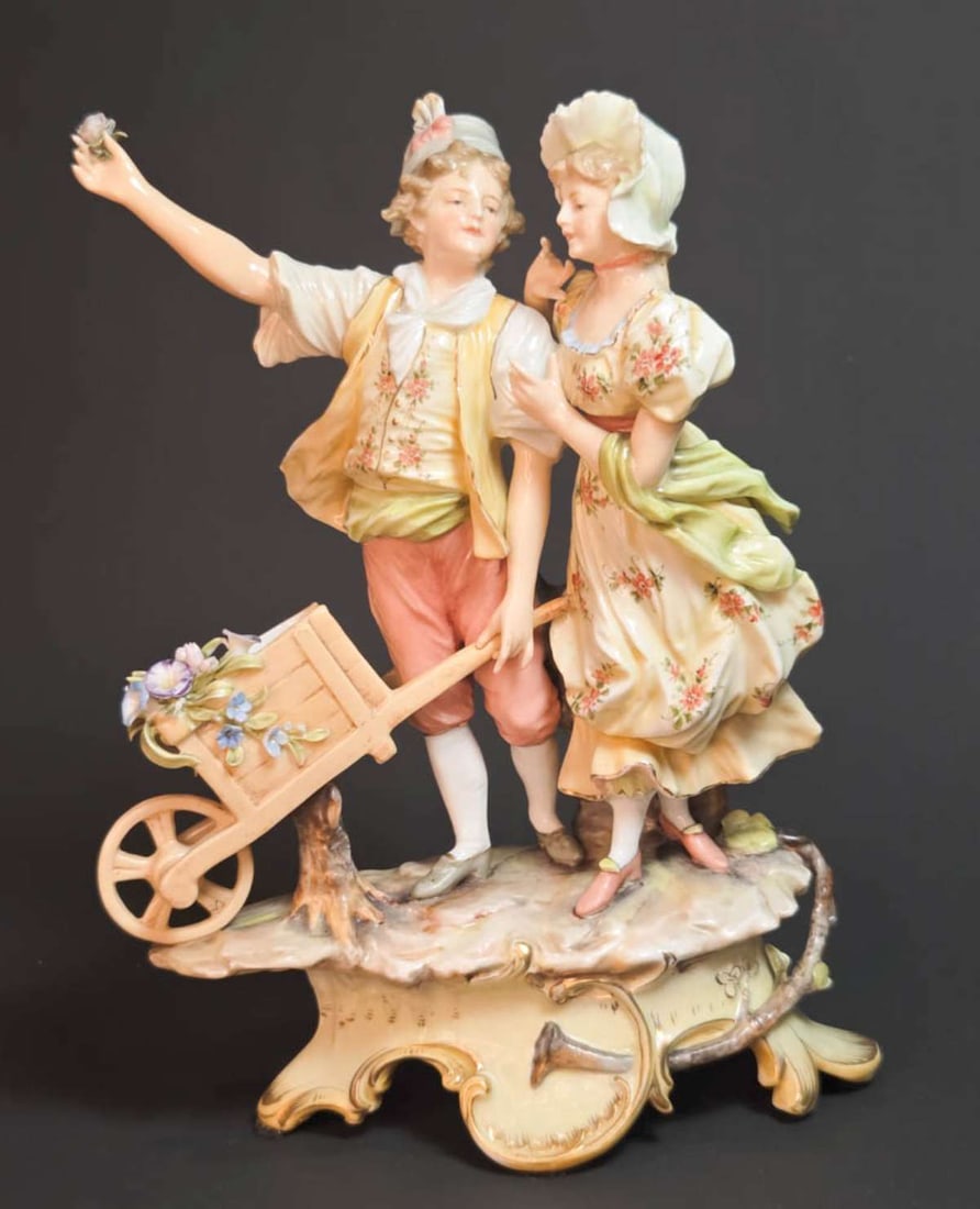 antique German Volkstedt porcelain figurine: marked underneath as shown for Rudolstadt-Volkstedt, beautiful antique figural statue shaped like a boy and a girl with a cart with flowers, note the intricate detail to the fingers and fa