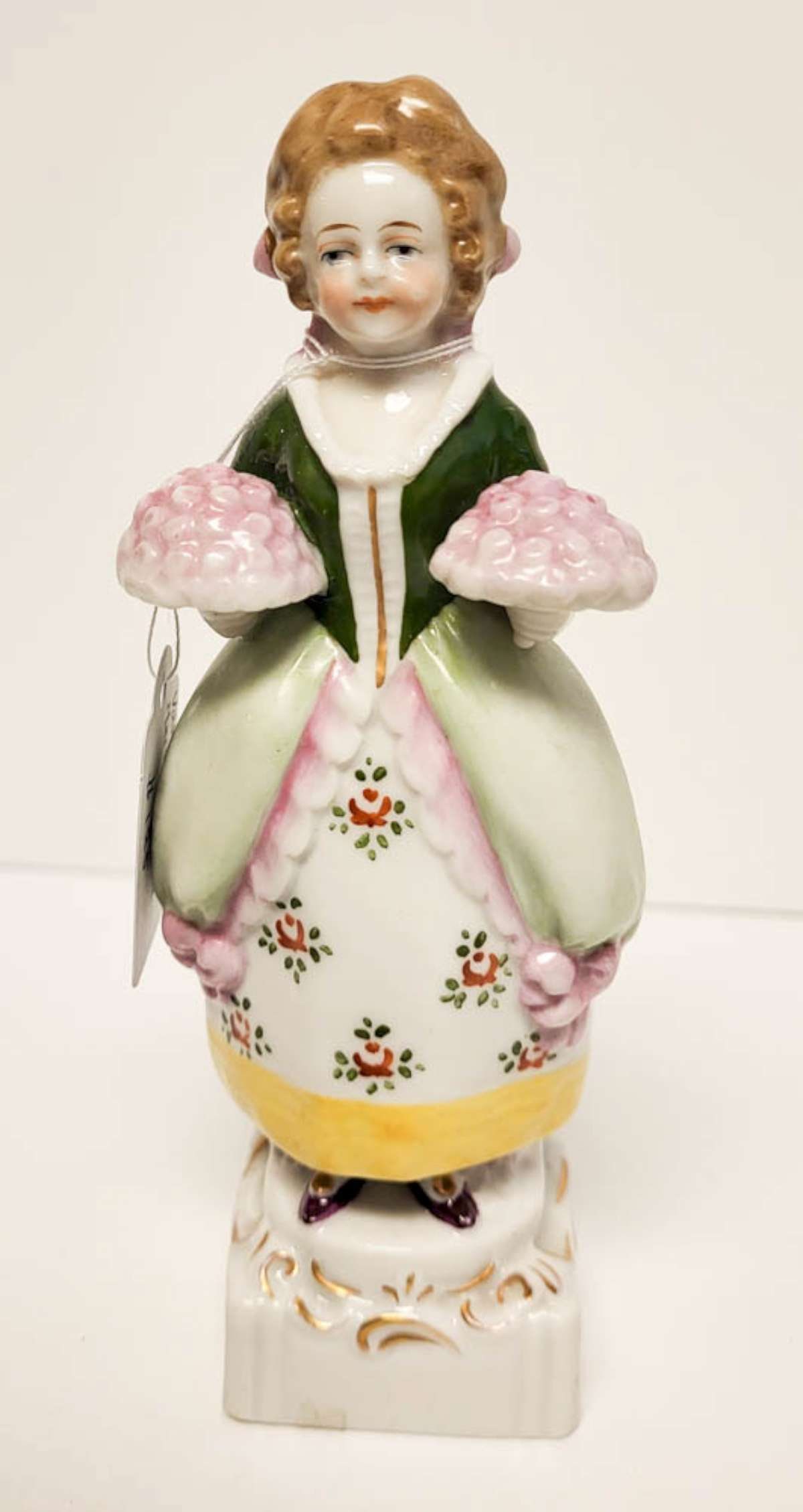 vintage porcelain figural statue: illegibly marked (German? French?) porcelain figurine depicting a young girl or woman in 1700's dress holding two plates of food, hand painted gilt accents