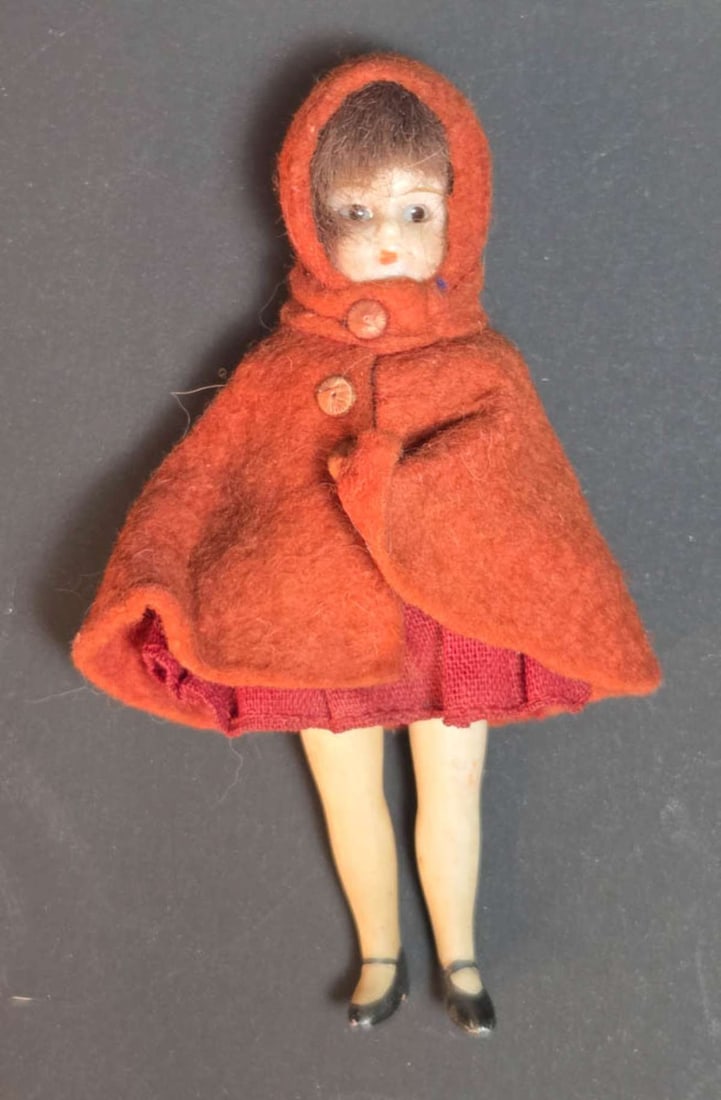 antique miniature dollhouse doll: early 1900's unmarked porcelain or bisque mini doll with movable arms and legs and what appears to be glass eyes, in fabric and needle felted wool red cape outfit, reminiscent of Litt