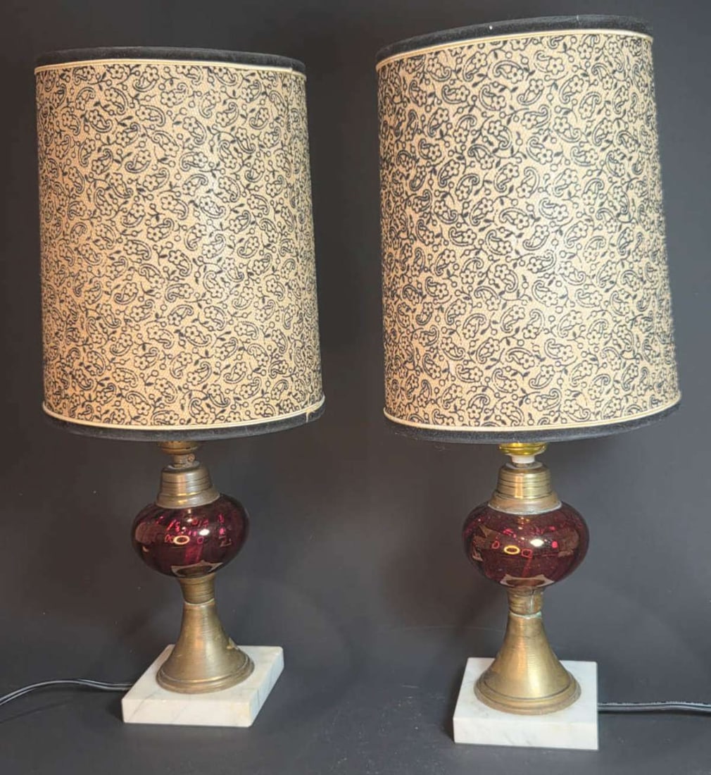 pair antique Cranberry glass table lamps: this is a matching pair of antique brass oil lamps (converted to electric) lamps with cranberry colored blown glass bodies and set on a white stone (marble?) base, with vintage clip-on (see clos