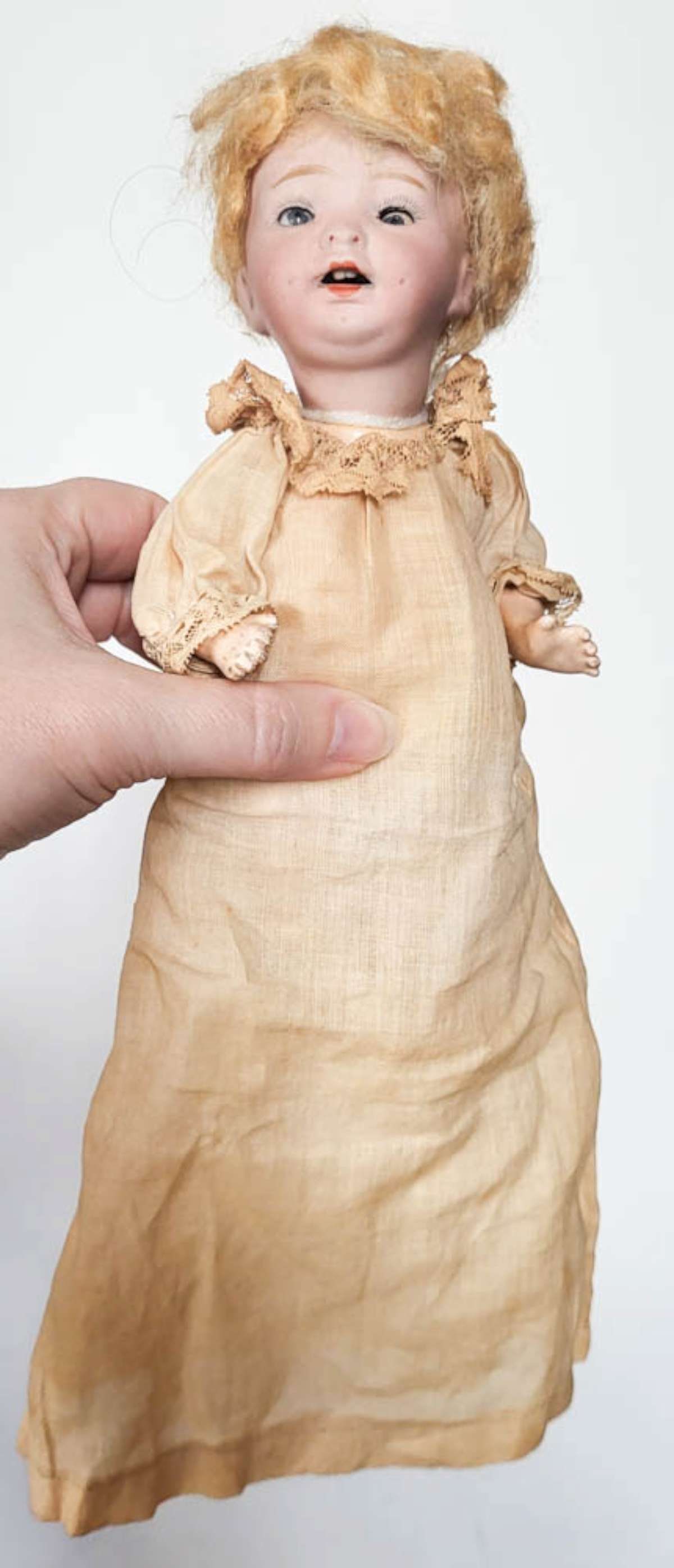 antique Morimura Bros porcelain head doll: cute small bisque or porcelain head baby doll with curly blonde wig, blue sleepy eyes, open mouth with teeth showing and composite body, arms and legs and antique linen long dress&co