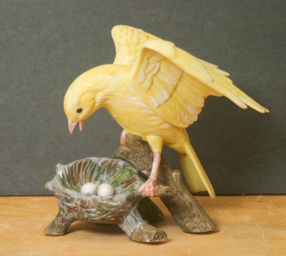 vintage Milano figural bird statue: porcelain or bisque figurine or statue by Milano Sculpture Eda Mann, shaped like a yellow Canary bird with a nest and two eggs