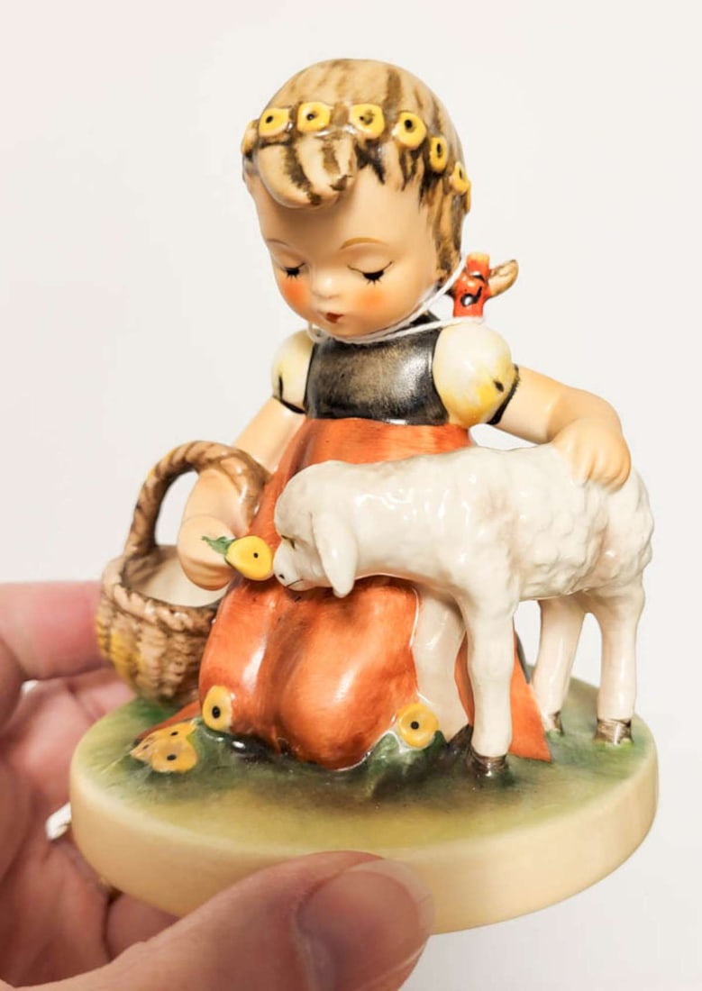 adorable Hummel girl statue by Goebel: vintage marked Goebel West Germany numbered 361 as shown figural Hummel figurine titled Favorite Pet, shaped like a girl in an orange skirt kneeling to feed flowers to a little lamb