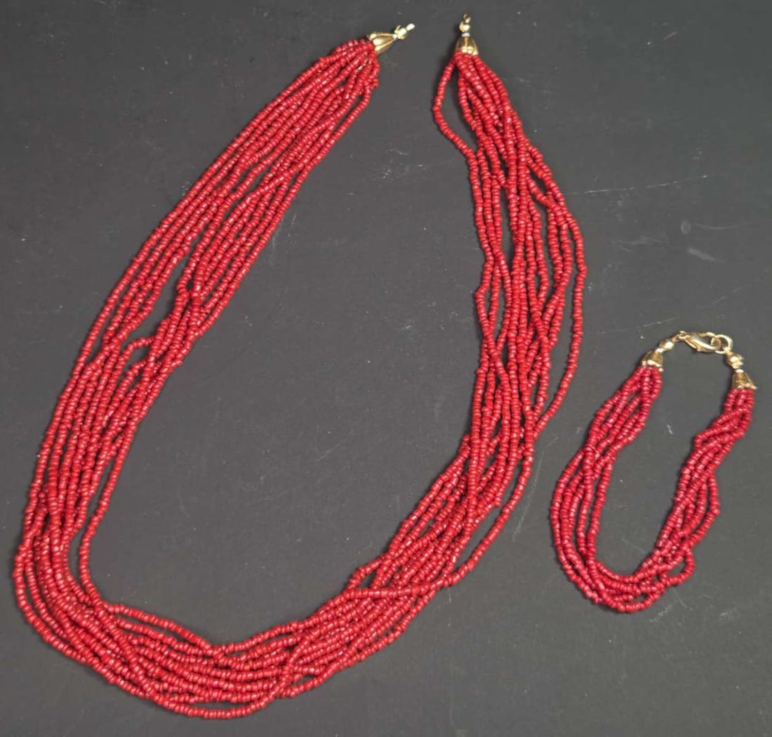 vintage estate jewelry: glass suite: red coral colored vintage or antique suite, consisting of a tiny red glass beaded necklace and matching bracelet, both multi-stranded and with gold toned closure (missing on necklace) neck