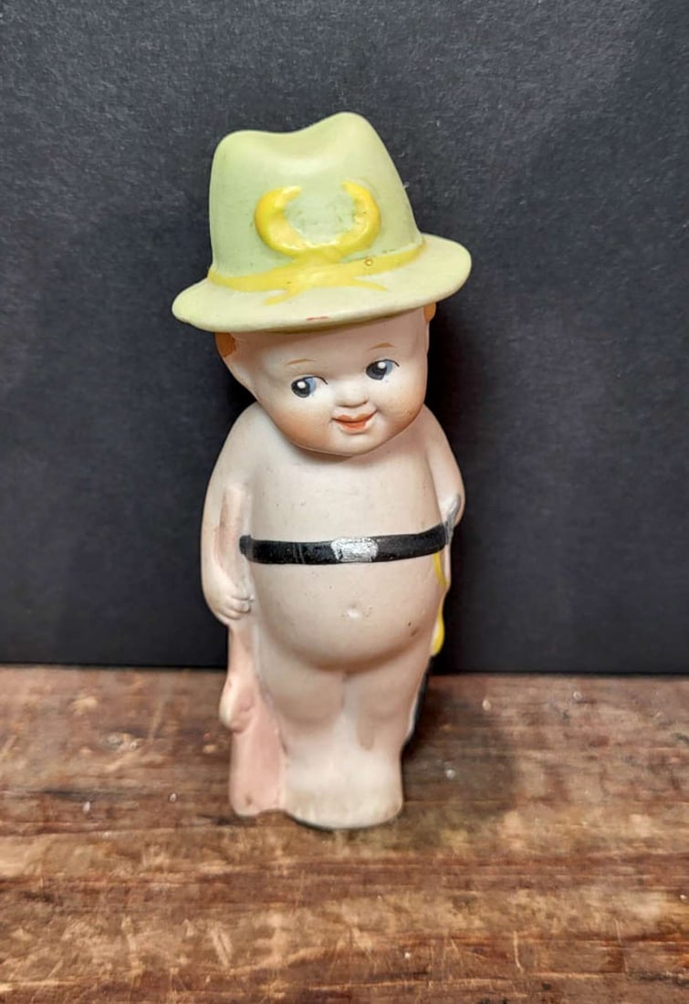miniature antique German bisque dollhouse doll: unmarked but likely early 1900's German made boy doll with green hat, side-glancing eyes and wearing a belt with sword about 3 7/8" tall