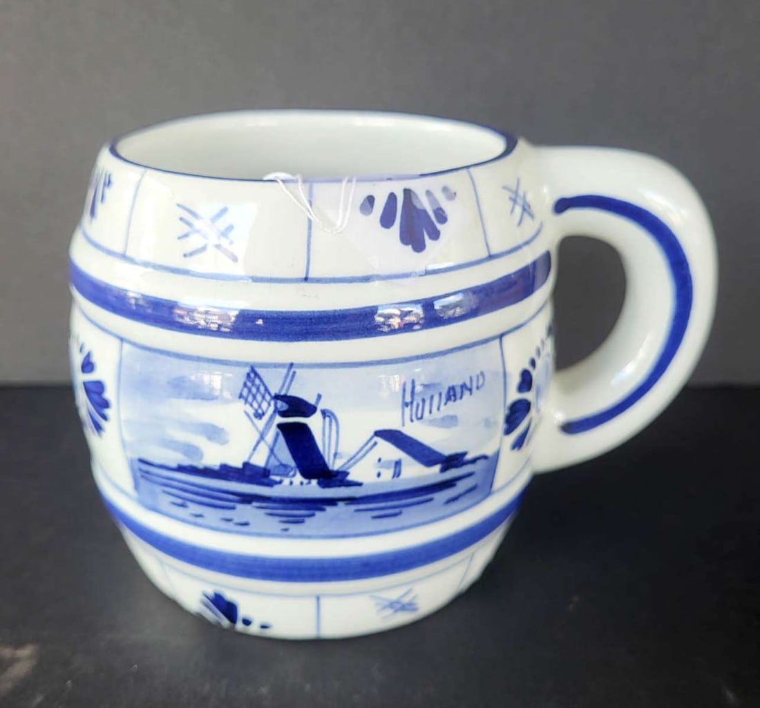 vintage Delft porcelain mug: vintage blue and white pottery handled mug with floral or flower design on one side and a windmill and farmhouse on the other side, marked Delft underneath as shown, from Holland or The Ne