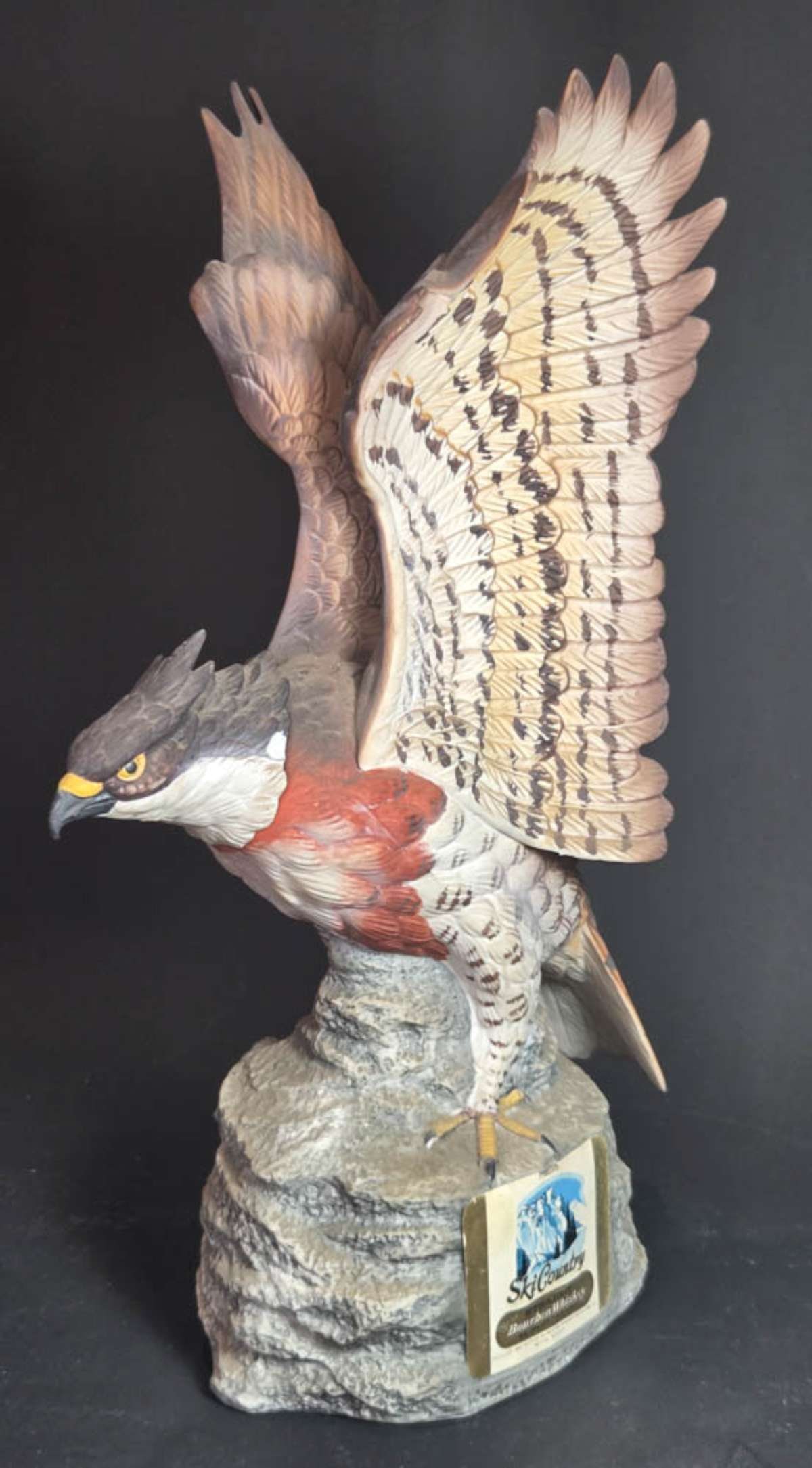 vintage figural animal liquor bottle: Ski Country limited edition Hawk Eagle decanter by Foss Company of Golden Colorado and made of bisque or porcelain and shaped like a bird about to take flight from a rock