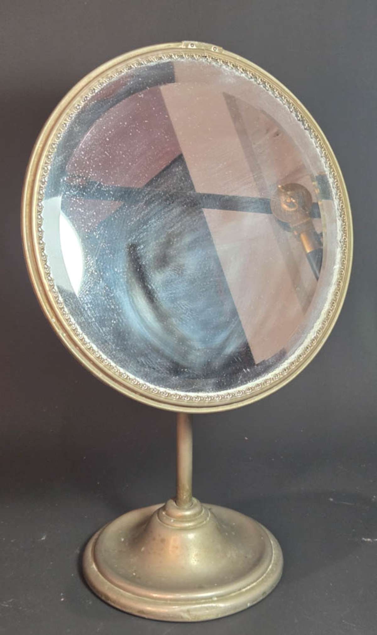 antique tabletop mirror: antique metal vanity or clothing or jewelry store table beveled edge mirror with adjustable face and round base about 13" tall overall, mirror diameter is 8 1/4" and base diameter