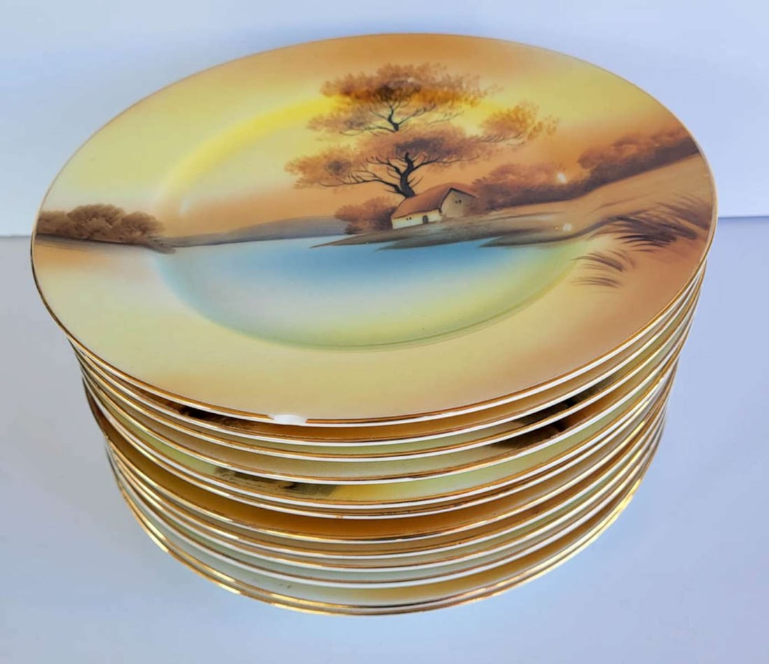 antique Japanese Noritake dinnerware set: fabulous porcelain antique Noritake hand painted set, consisting of 12 matching dinner plates with yellow orange background with blue lake scene with trees and a house in the background diameter