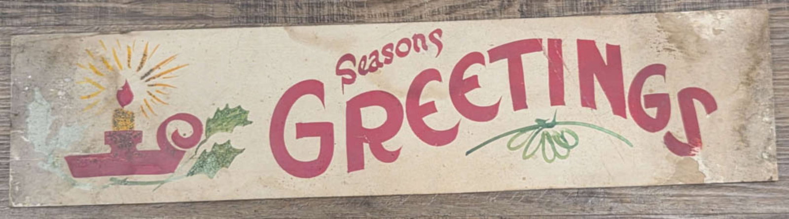 antique General store display Holiday sign: heavy cardstock with hand painted and glitter Seasons Greeting Christmas sign with Holly and a burning candle about 27 5/8" long by 6 3/8" high
