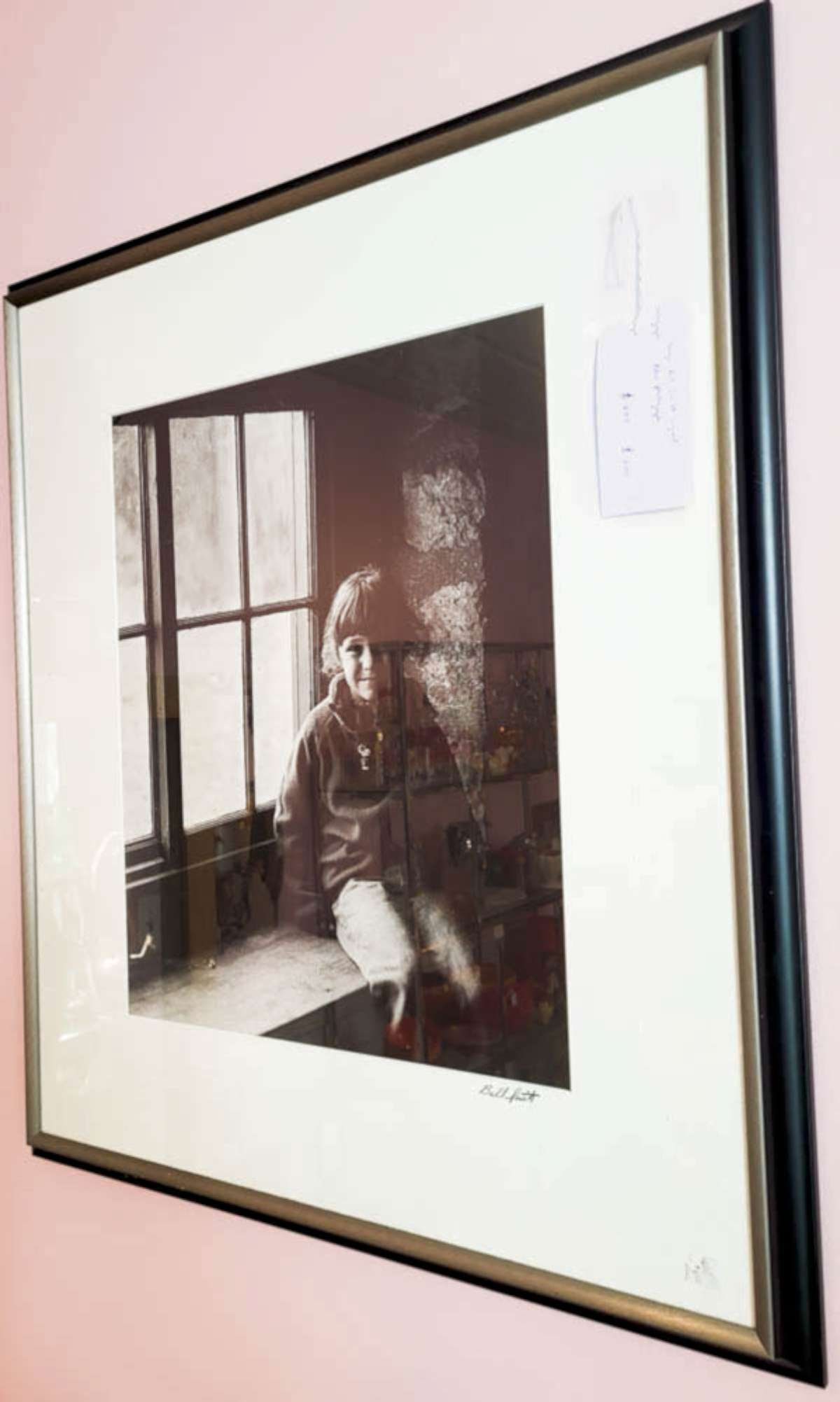 original Bill Smith b/w photograph: nicely framed and matted original black and white photograph signed Bill Smith lower right and depicting a young girl sitting in the stone built house's windowsill with a window backlighting her 